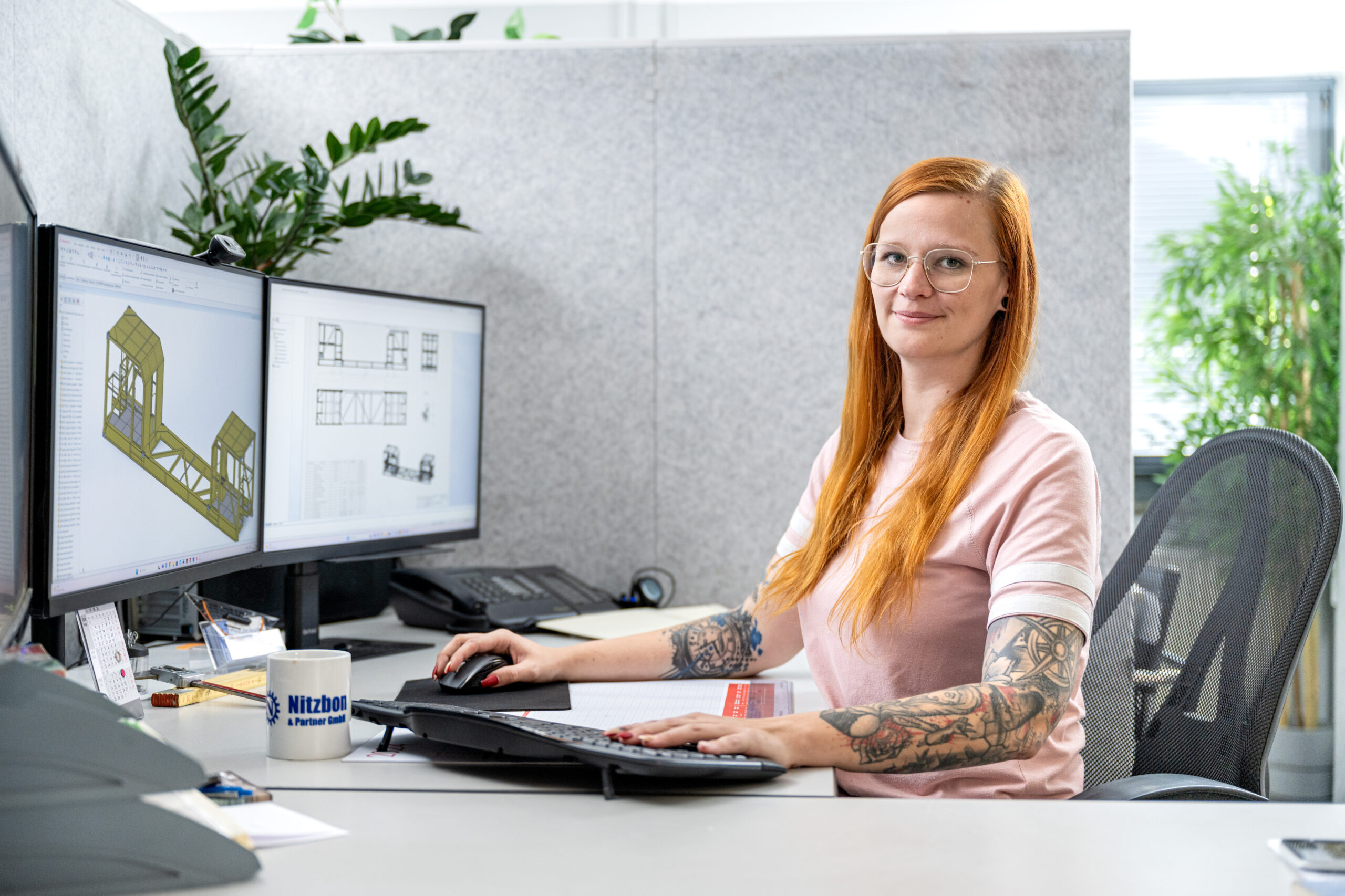 Mitarbeiterin im Büro arbeitet am Computer an 3D-Konstruktionsplänen